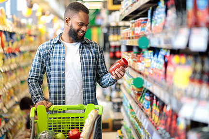 Man Doing Grocery Shopping Standing With Cart Choosing Food Indoors